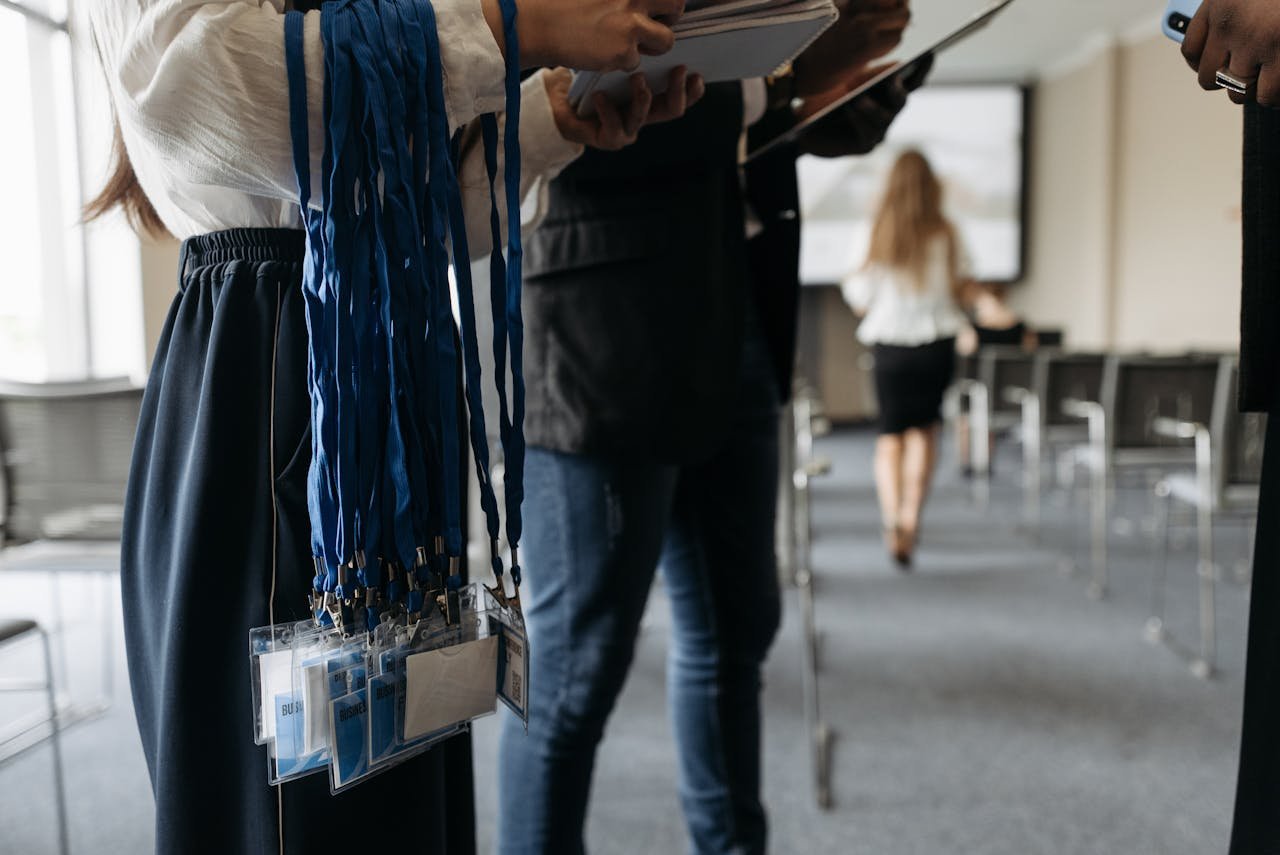 home-hero People in a conference room preparing with lanyards and badges.
